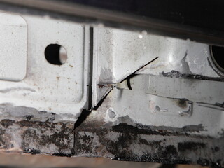 Car rocker panel door inside closeup, cleaning it from rust to clean metal, rust converter...