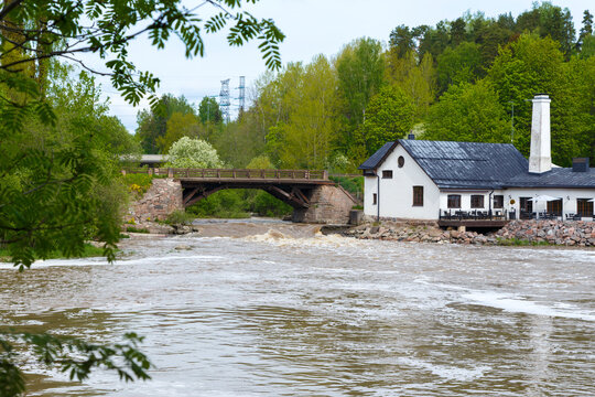 Old bridge and building by the rapid and River Vantaa at the Vantaankoski nature trail in Vantaa, Finland, on a sunny day in the summer.