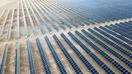 Array of solar panel power plant on desert landscape aerial 