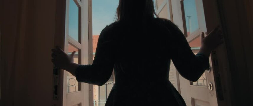 A Young Woman Opening A Door Of Her Apartment In Europe And Going Out To The Balcony With Medieval Buildings And Old Town View. Travel, European Summer Vacation. Slow Motion, Handheld, Dolly In. 