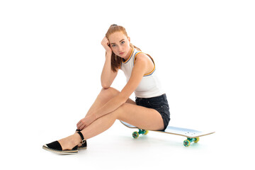 Fototapeta na wymiar Red hair young model with skateboard in studio on white background