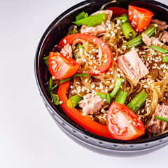 delicious glass noodles with tuna and vegetables on a white acrylic background