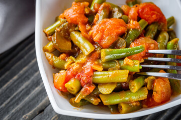 stewed green beans on a dark wooden rustic background