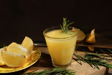 Traditional Italian alcoholic drink limoncello. Shot glass of limoncello decorated rosemary and fresh lemons.