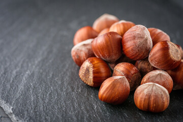 fresh natural hazelnuts on a dark stone background