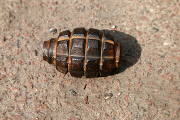 close up of an rusty grenade on the ground