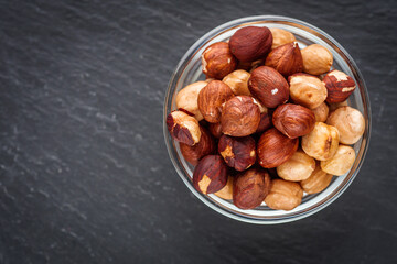 fresh natural hazelnuts on a dark stone background