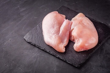 raw chicken fillet on a dark stone background