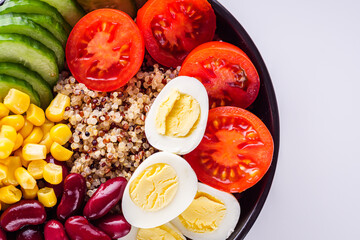 bowl of healthy quinoa with vegetables on a white background
