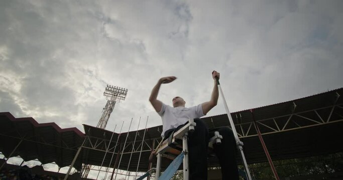 Handicapped sportsman throwing disc on stadium