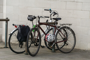 Fototapeta na wymiar A Photograph of Two Cycles Parked On a Bicycle Parking Rack In a Urban Scene in City Centre