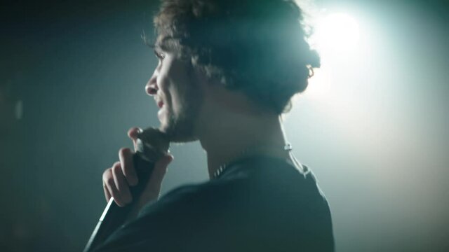 CU Portrait of young Caucasian male comedian performing his stand-up monologue on a stage of a small venue. Shot with ARRI Alexa Mini LF with 2x anamorphic lens