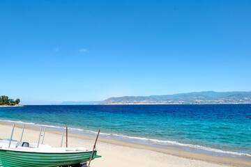 Sandy beach in Messina with views of Calabria and the Messina strait. Tourist season on the mediterranean sea. Sicily. Ionian sea.
