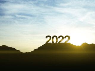 2022 happy new year sign on top of the mountain with sunset, symbol of new success and opportunities