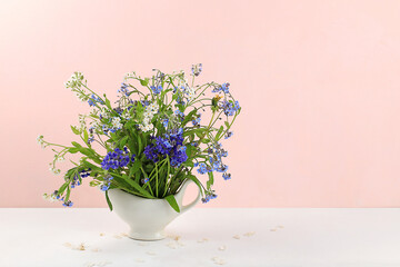 Home interior with decor elements, beautiful spring garden flowers in a vase on a light background, abstract flower arrangement, still life with place for text, floral card for birthday, wedding,