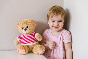 One and a half year old girl playing
with a teddy bear. Taking care of children