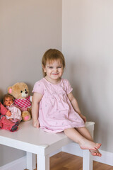 One and a half year old girl playing
with a teddy bear. Taking care of children