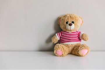 Teddy bear on a dresser against a light wall