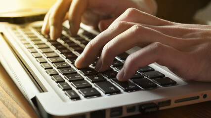 Hands from business man person typing or texting on notebook laptop computer keyboard.