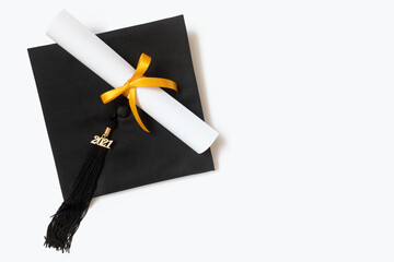 Graduation cap and diploma on a white background
