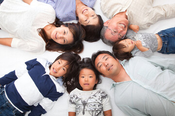 Japanese 3rd generation family lying down and looking at the camera