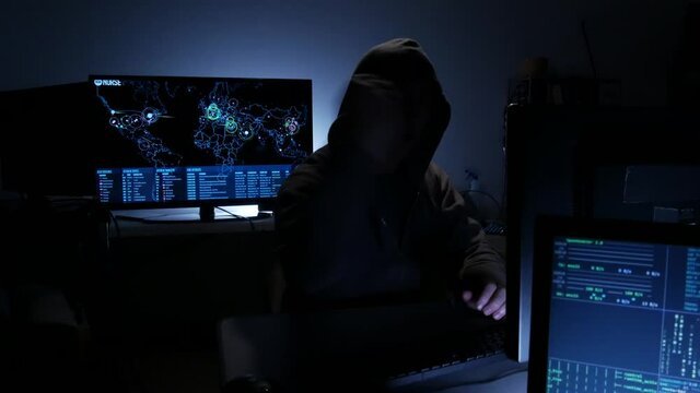 Computer hacker types code attempting to hack a computer server