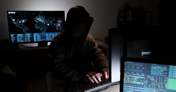 Computer hacker types code attempting to hack a computer server
