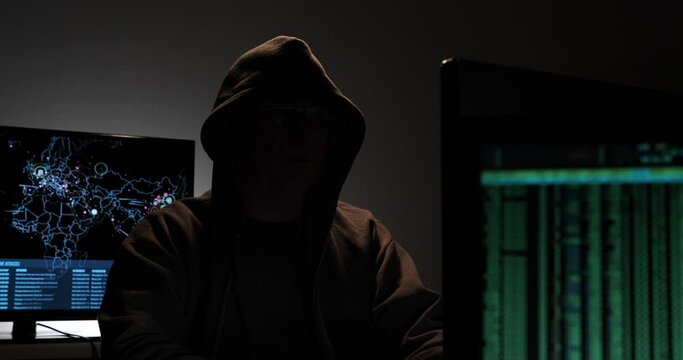 Computer hacker types code attempting to hack a computer server