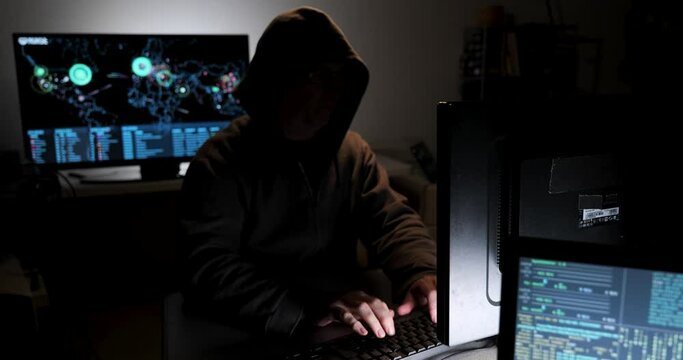 Computer hacker types code attempting to hack a computer server