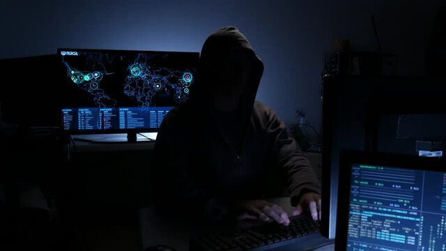 Computer hacker types code attempting to hack a computer server