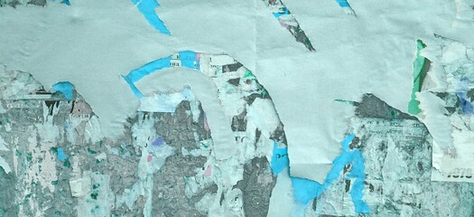 Artistic Urban Street Background with Grungy Wall with Ripped, Torn And Peeled Posters. Old Wall with Scratched Advertising. Old Billboard with Torn Posters. Vintage Wide Background and Texture.