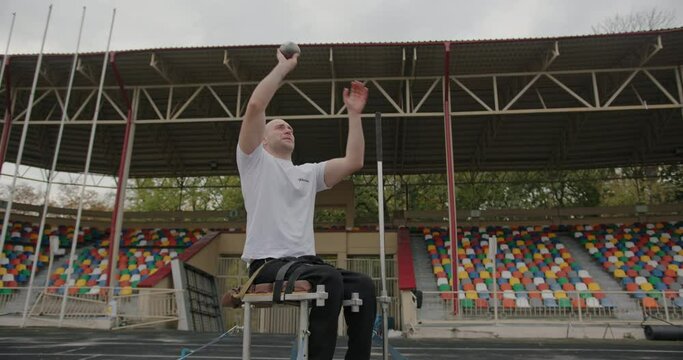 Sportsman with disability putting shot on arena