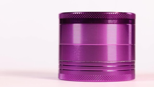  Purple aluminum marijuana bud grinder spinning isolated over white.