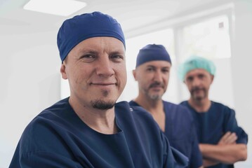 Multiethnic orthopedic doctor in front of his medical team looking at camera wearing face mask 