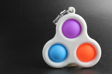 colorful antistress sensory toy fidget push pop it simle dimle on black background