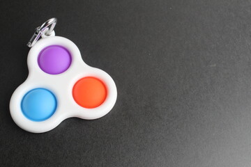 colorful antistress sensory toy fidget push pop it simle dimle on black background