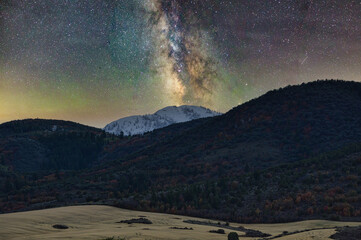 Superb shot of colorful Milky Way glowing in the sky seen through moutains