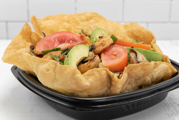 Shrimp taco salad served in a crispy tostada bowl will fill your appetite perfectly