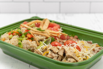 Long shaped bowl of protein including diced chicken, quinoa, beans, cheese, and rice for a delicious flavor explosion