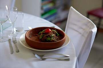 buckwheat soba noodles with herbs and tomatoes in a wooden plate on a white table restaurant