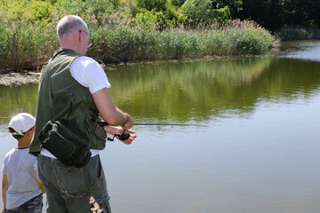 Father teaching little son how to fishing