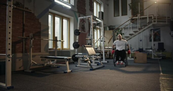 Male boxer riding wheelchair towards camera