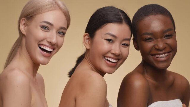 Natural beauty diversity. Studio portrait of three happy multiethnic ladies laughing to camera, enjoying spa procedures