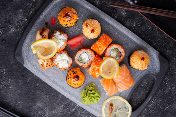 sushi roll set served at grey tray at black table. flat lay.