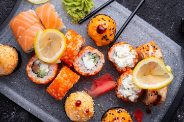 sushi roll set served at grey tray at black table. flat lay. close up