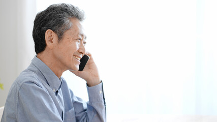 携帯電話で電話する高齢の男性　ポジティブ