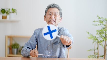 不正解の札を出す高齢の男性