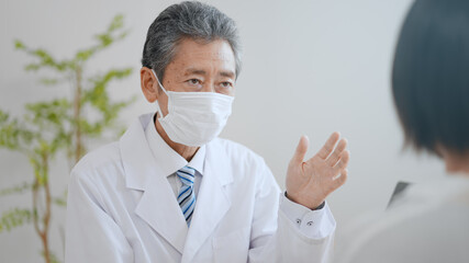 マスクをかけた高齢の男性医師イメージ　笑顔