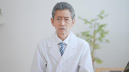高齢の男性医師　険しい表情