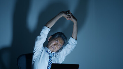 残業する高齢ビジネスマンイメージ　ストレッチ